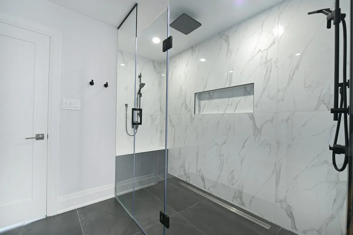 shower glass partition marble Frameless shower glass partition in a marble bathroom